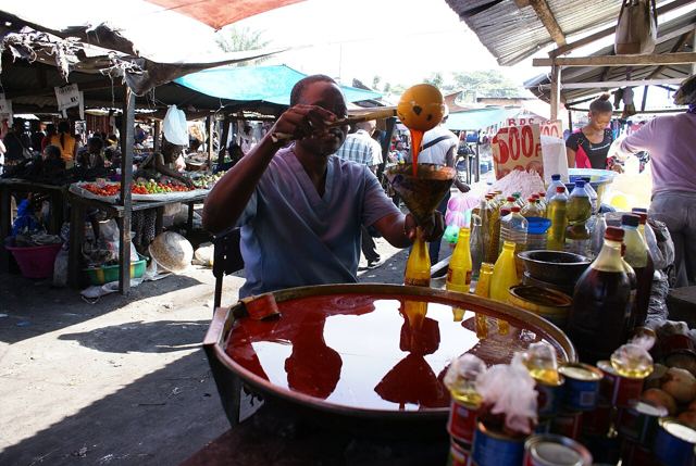 Vendeur d'huile de palme sur un marché congolais